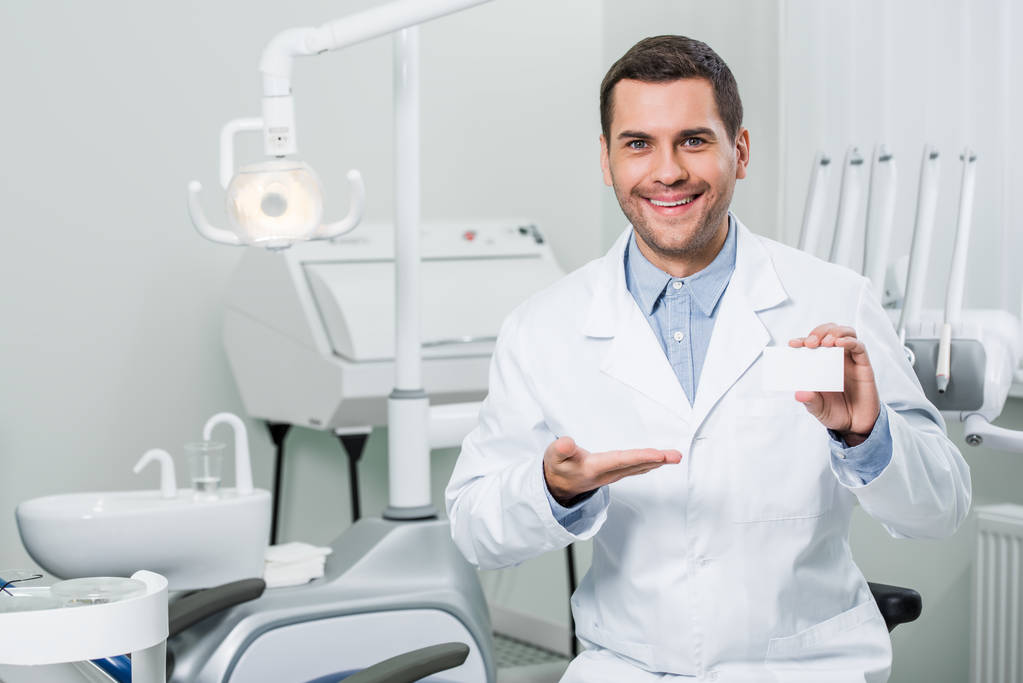stock-photo-cheerful-dentist-white-coat-smiling