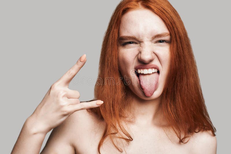 feeling-free-close-up-portrait-young-cute-teenage-girl-long-red-hair-showing-hand-sign-sticking-out-studio-shot-tongue-214323506.jpg