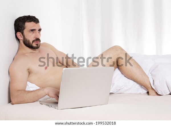 bearded-latin-man-bed-laptop-600w-199532018.jpg